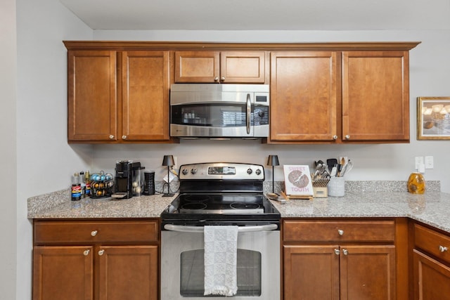 kitchen with stainless steel appliances and light stone countertops