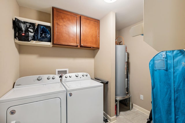 washroom featuring water heater, cabinets, and independent washer and dryer