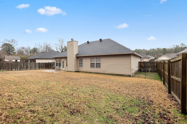 rear view of house with a patio and a yard