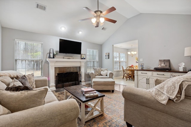 living room featuring ceiling fan with notable chandelier, a fireplace, and high vaulted ceiling