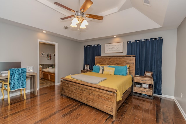 bedroom with ceiling fan, dark hardwood / wood-style floors, and a raised ceiling