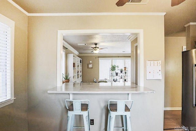 kitchen with crown molding, high quality fridge, and ceiling fan