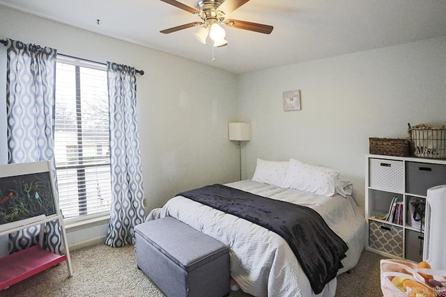 carpeted bedroom featuring multiple windows and ceiling fan