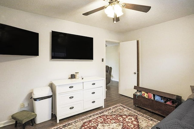 living room featuring ceiling fan, dark hardwood / wood-style floors, and a textured ceiling