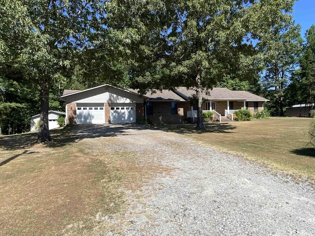 single story home featuring a porch, an outdoor structure, and a front yard