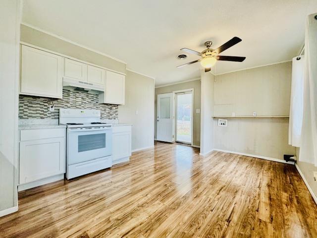 kitchen with tasteful backsplash, white cabinets, white electric range oven, ceiling fan, and light wood-type flooring