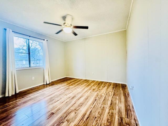 unfurnished room featuring crown molding, hardwood / wood-style flooring, and ceiling fan