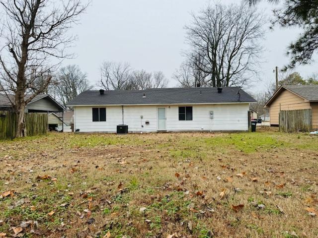 rear view of property featuring a lawn