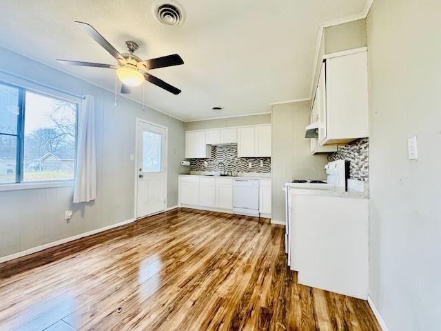 kitchen featuring white cabinetry, decorative backsplash, hardwood / wood-style flooring, ceiling fan, and white dishwasher