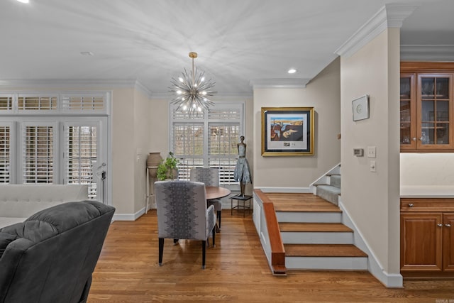 dining area featuring a notable chandelier, crown molding, and light hardwood / wood-style flooring