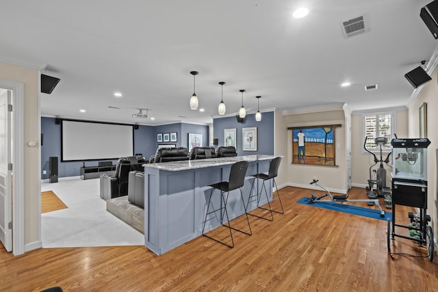 cinema featuring crown molding and light hardwood / wood-style floors