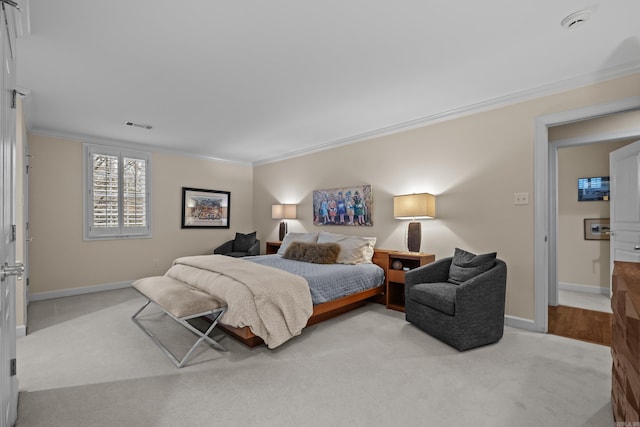 bedroom with ornamental molding and light colored carpet