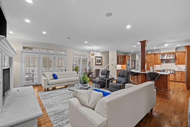 living room featuring crown molding, light hardwood / wood-style floors, and a chandelier