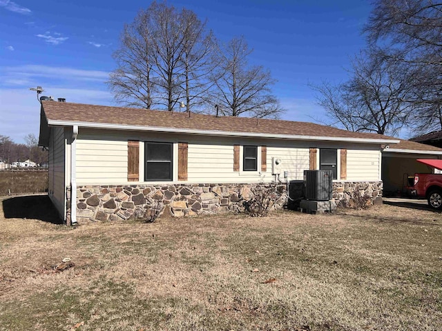 view of side of property with central AC unit and a lawn