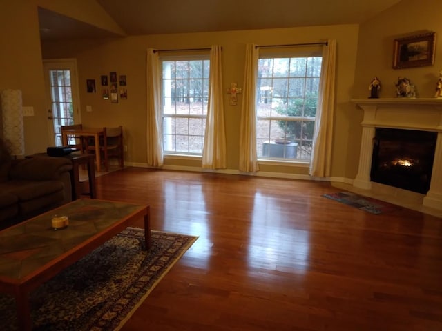 living room featuring lofted ceiling, a healthy amount of sunlight, and hardwood / wood-style floors