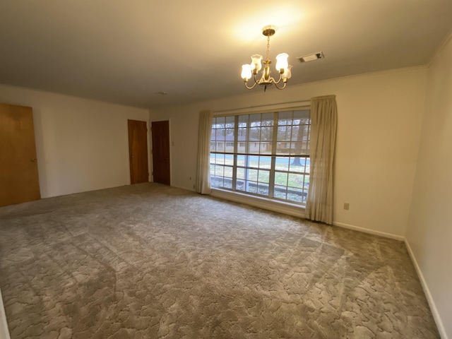 empty room featuring ornamental molding, carpet flooring, and a chandelier