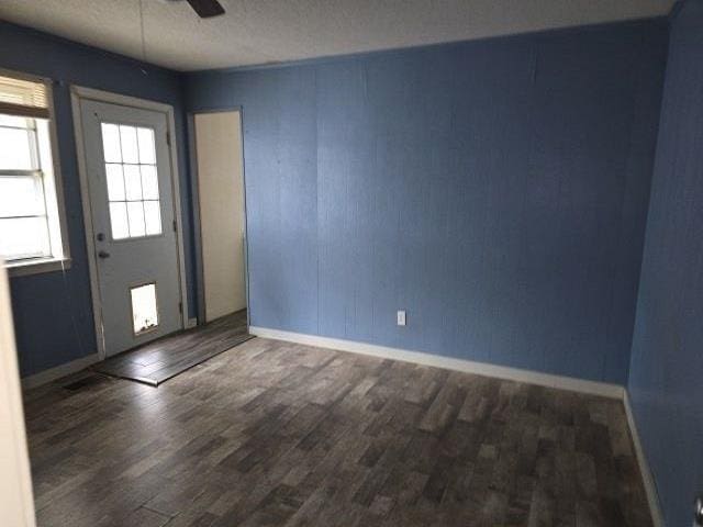 entryway featuring dark hardwood / wood-style flooring, a textured ceiling, and ceiling fan