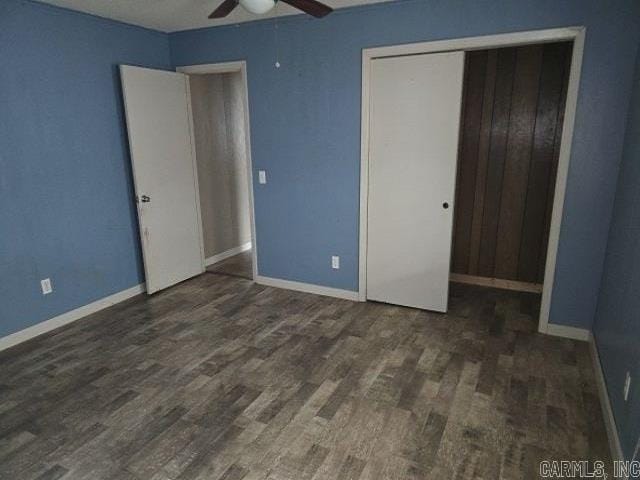 unfurnished bedroom featuring dark wood-type flooring, a closet, and ceiling fan