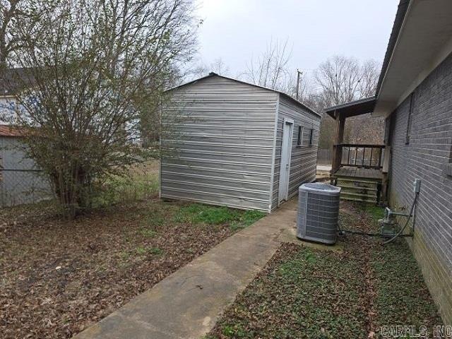 view of side of home with cooling unit and a shed