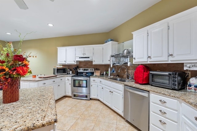 kitchen with light tile patterned flooring, tasteful backsplash, white cabinetry, sink, and stainless steel appliances