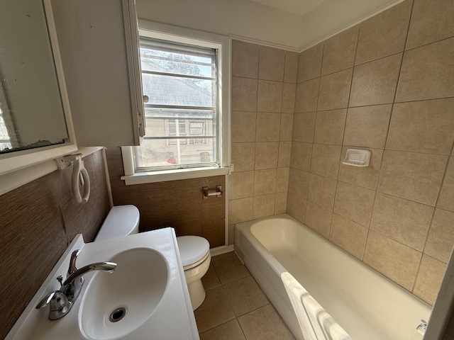 bathroom featuring tile patterned flooring, sink, tile walls, and toilet