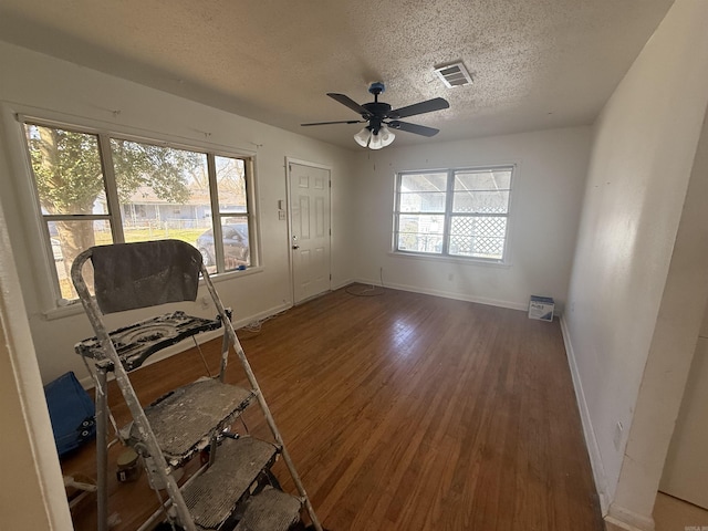 interior space featuring hardwood / wood-style flooring, ceiling fan, and a textured ceiling