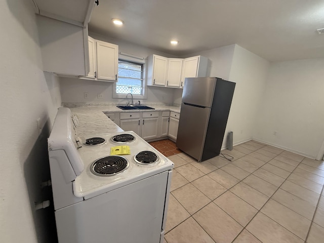 kitchen featuring light tile patterned flooring, white electric range oven, sink, white cabinetry, and stainless steel fridge