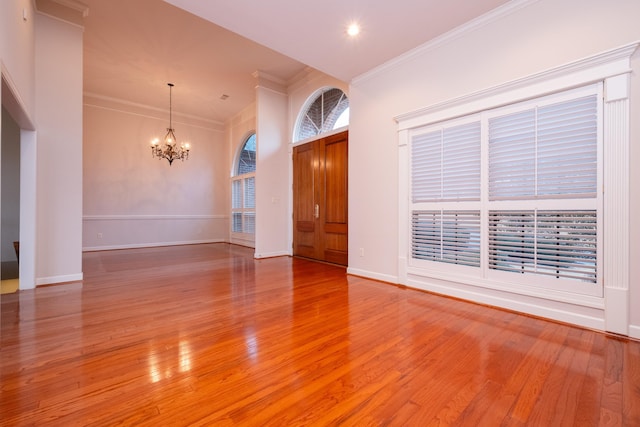 entrance foyer featuring hardwood / wood-style flooring, crown molding, and an inviting chandelier