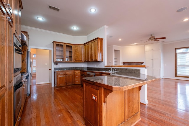 kitchen featuring sink, crown molding, a breakfast bar area, stainless steel appliances, and a center island