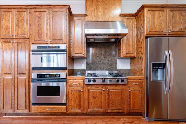 kitchen featuring tasteful backsplash, extractor fan, and appliances with stainless steel finishes