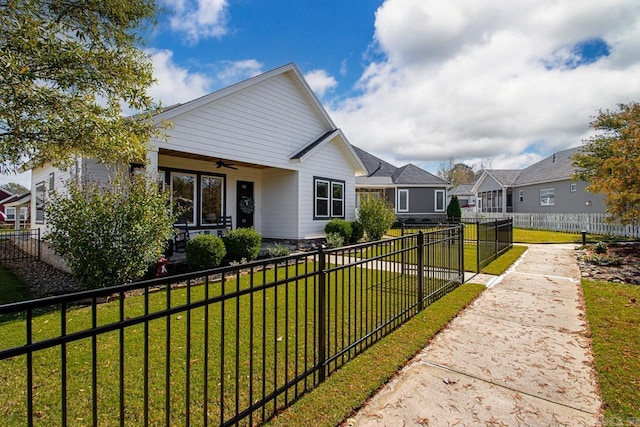 view of front of property featuring ceiling fan and a front lawn