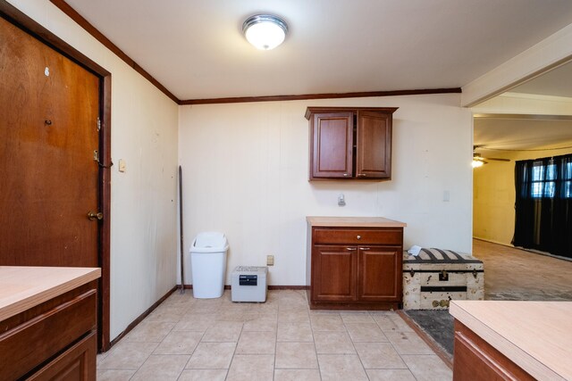 kitchen with light tile patterned flooring, ceiling fan, and ornamental molding