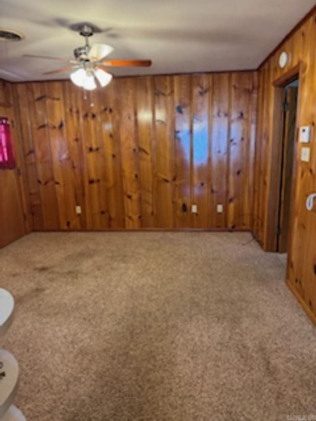 1985 Old Wire Rd, Camden, AR 71701 - unfurnished living room with light carpet, ceiling fan, and wood walls
