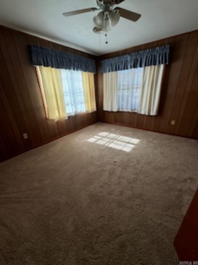1985 Old Wire Rd, Camden, AR 71701 - empty room featuring wood walls, a ceiling fan, and carpet flooring