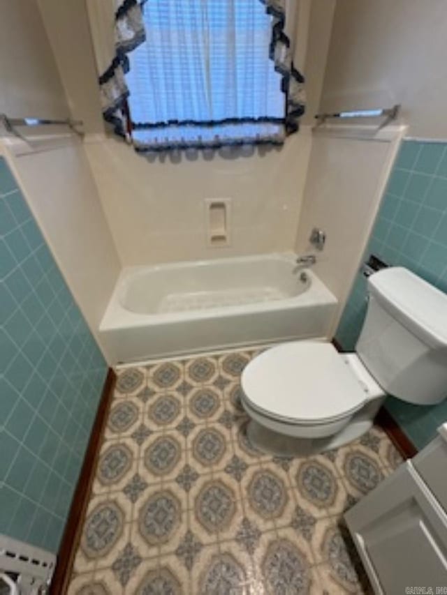 1985 Old Wire Rd, Camden, AR 71701 - full bathroom with tile patterned flooring, toilet, a wainscoted wall, tile walls, and tub / shower combination