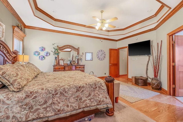 bedroom featuring ceiling fan, ornamental molding, and a tray ceiling