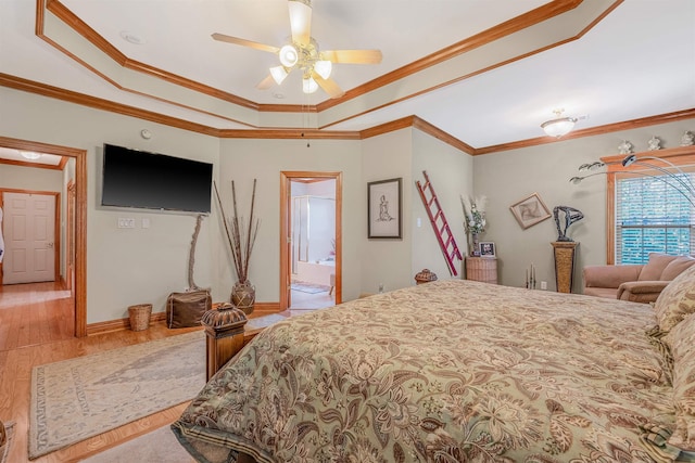 bedroom with crown molding, ensuite bathroom, a raised ceiling, and light hardwood / wood-style floors