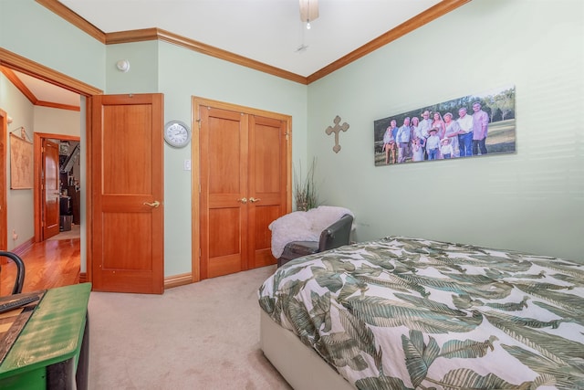 bedroom with crown molding, light colored carpet, and a closet