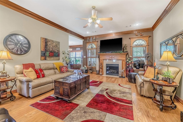 living room featuring ceiling fan, ornamental molding, light hardwood / wood-style flooring, and a wealth of natural light