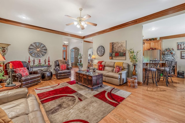 living room with crown molding, light hardwood / wood-style flooring, and ceiling fan