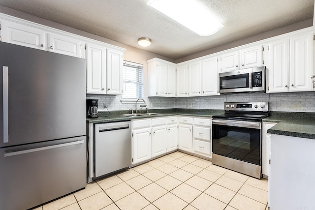 kitchen with tasteful backsplash, stainless steel appliances, sink, and white cabinets