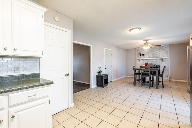 kitchen with white cabinetry, backsplash, ceiling fan, and light tile patterned flooring