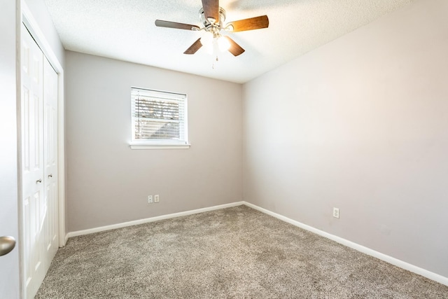 carpeted empty room with ceiling fan and a textured ceiling