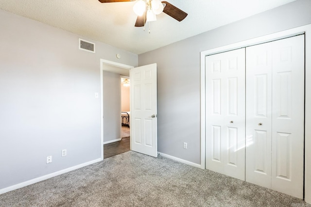 unfurnished bedroom with light colored carpet, a textured ceiling, ceiling fan, and a closet