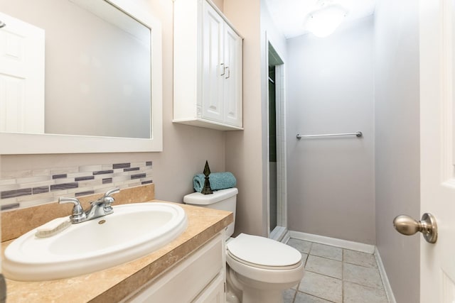 bathroom with vanity, backsplash, tile patterned floors, and toilet