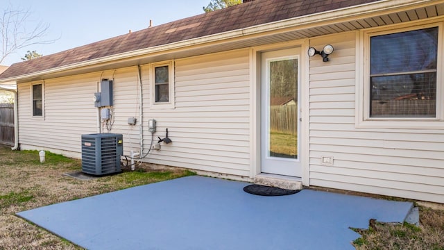 view of exterior entry with a patio area and central air condition unit