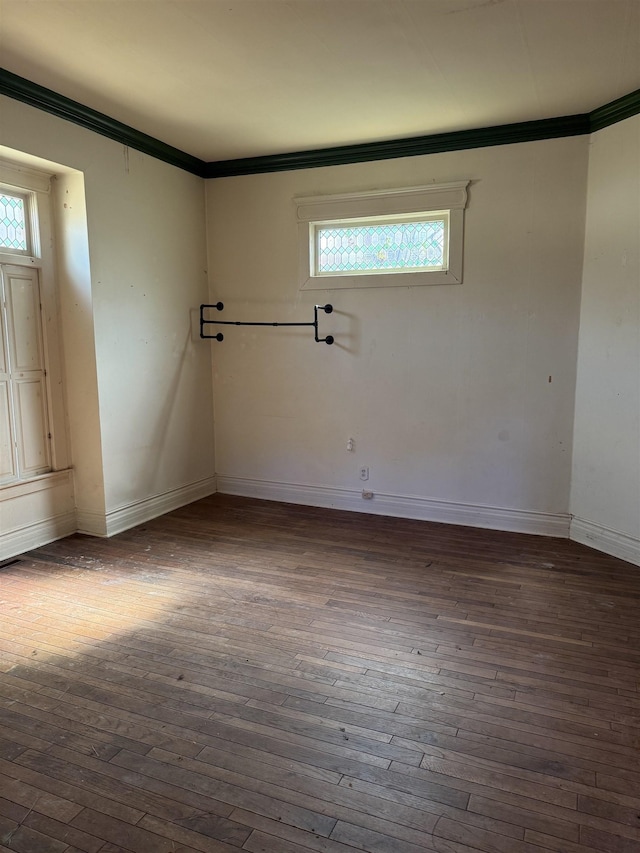 unfurnished room with ornamental molding and dark wood-type flooring