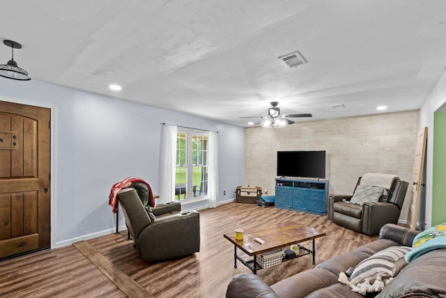 living room with ceiling fan and light hardwood / wood-style flooring