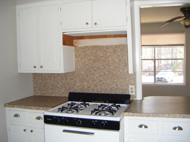 kitchen featuring ceiling fan, white gas range oven, decorative backsplash, and white cabinets