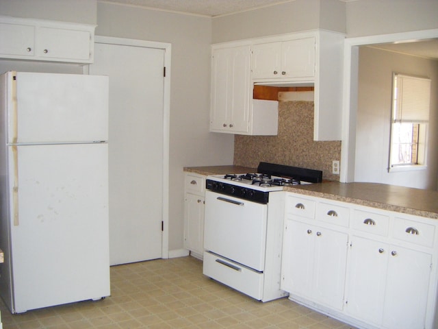 kitchen with tasteful backsplash, white appliances, and white cabinets